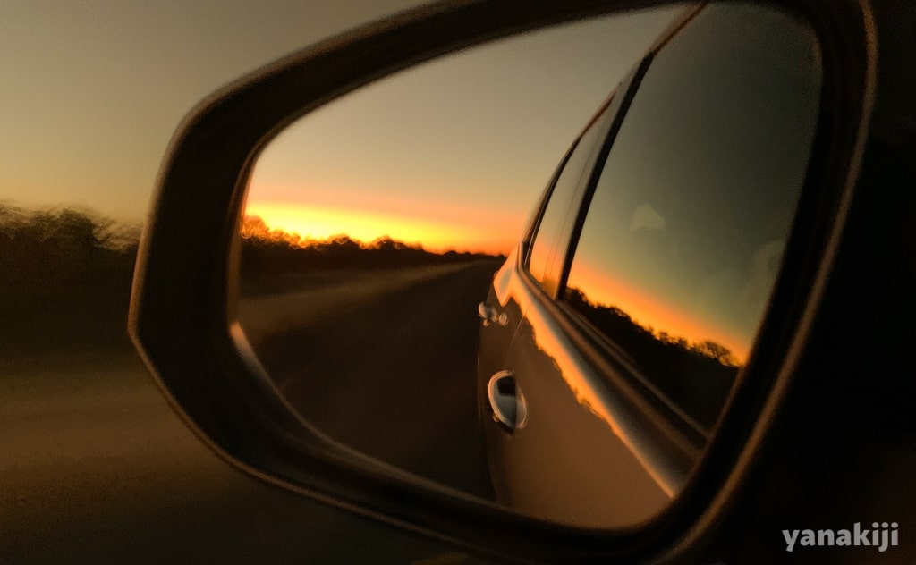 車のミラーに写る夕日