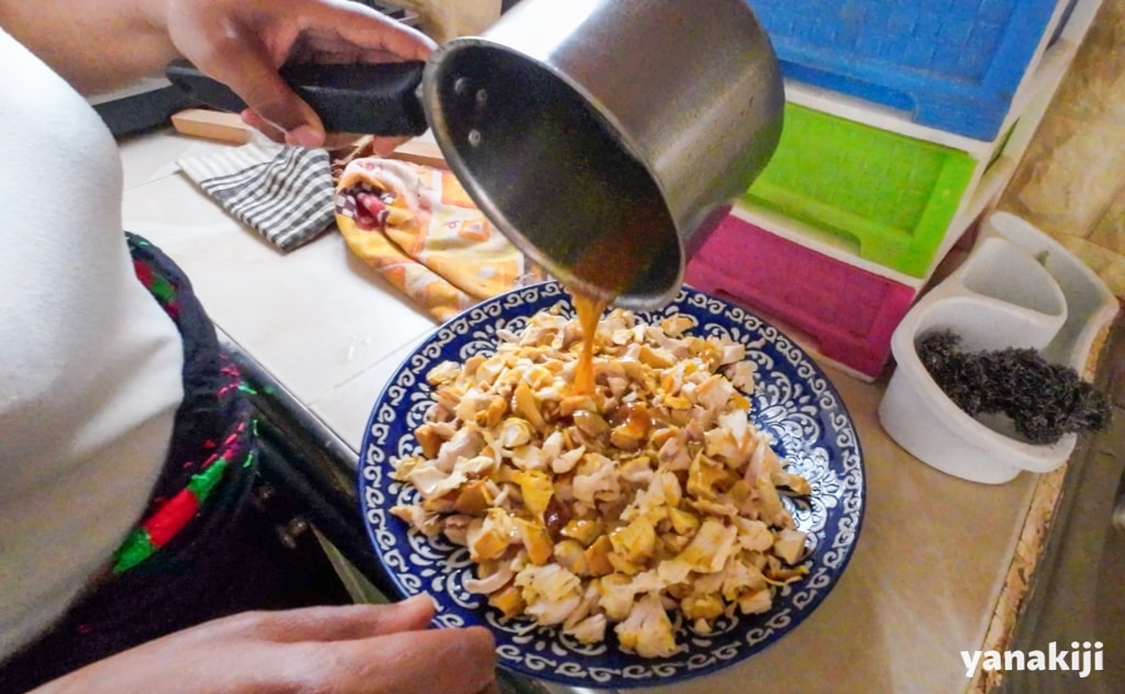 ほぐした鶏肉にオニオンソースをかける