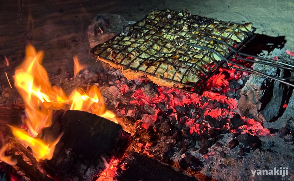 焚き火で肉を焼く